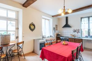 a kitchen with a table with a red table cloth at La Pierre Blanche 