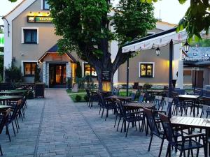 puste patio ze stołami i krzesłami przed budynkiem w obiekcie Hotel & Restaurant Pod Kaštany w mieście Krupka