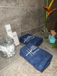 dos toallas azules sentadas en un mostrador con un frasco en Hilltop Boutique Hotel en Victoria