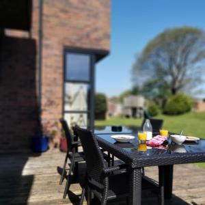 - une table noire avec des chaises et des boissons sur la terrasse dans l'établissement Portreeves, à Arundel