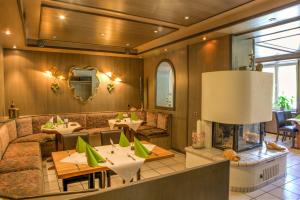 a restaurant with couches and tables and a fireplace at Moselromantik Hotel Am Panoramabogen in Cochem
