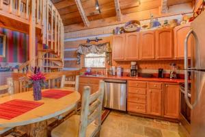eine Küche mit Holzschränken, einem Tisch und einem Kühlschrank in der Unterkunft #152 Moonshadow in Townsend