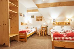 a bedroom with two beds and a table and chairs at Tatra House Residence in Zakopane