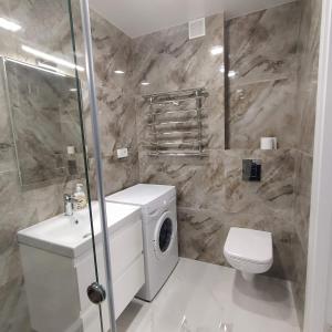 een badkamer met een wastafel en een wasmachine bij VIP Apartment near Center in Lviv