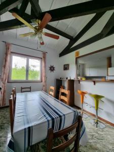 uma sala de jantar com uma mesa e uma ventoinha de tecto em villa relax em Ascain