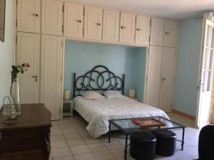 a bedroom with a bed and a coffee table at La Sabatière in Bergerac