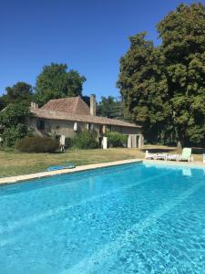 a large swimming pool in front of a house at La Sabatière in Bergerac