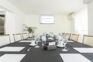 une salle de conférence avec une longue table et des verres à vin dans l'établissement Mediterráneo Hotel y Spa, à Rosario