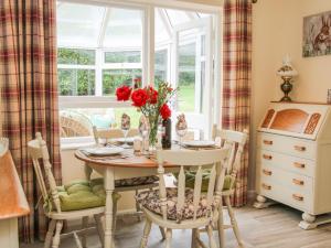 a dining room with a table and chairs and a window at Glen Helen in Telford