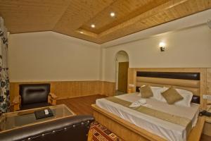 1 dormitorio con cama, bañera y silla en Hotel Rockland Inn, en Manali