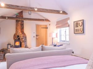 a living room with three beds and a fireplace at The Forge in Stowmarket