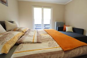 a bedroom with a bed with a blanket on it at FABIAN - Ski und Thermen Appartement in Bach