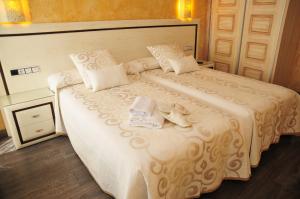 a bedroom with a large white bed with towels on it at Hostal Rabel in Ponferrada