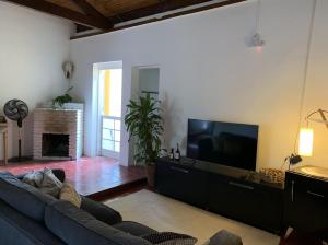a living room with a couch and a flat screen tv at Hospedagem Fazenda Nova América in Brotas