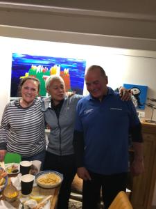 three people standing next to a table with food at Dunnottar Cottage in Stonehaven