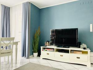 ein Wohnzimmer mit einem TV in einem weißen Unterhaltungszentrum in der Unterkunft Neptun by Baltic Home in Misdroy