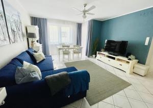 ミエンジズドロイェにあるNeptun by Baltic Homeのリビングルーム(青いソファ、テレビ付)