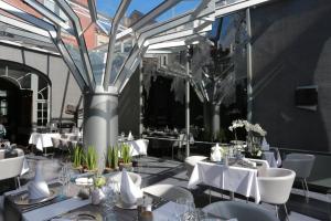 um restaurante com mesas brancas e cadeiras brancas em Boutique Hôtel, La Cour de la Reine, Rooftop city center em Spa