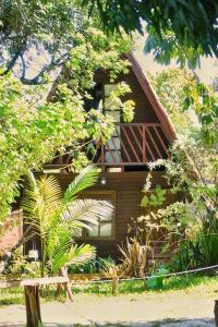 Casa de madera con ventana y árboles en Chalet Suisse en Natal