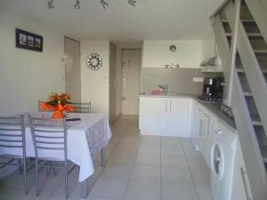 uma cozinha com uma mesa e algumas cadeiras e uma mesa e uma mesa; em Maison avec piscine collective sur Gruissan 6MIN39 em Gruissan