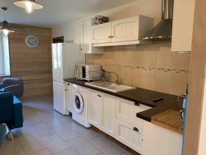 a kitchen with a sink and a washing machine at Gites des Casernes in Saint-Christophe
