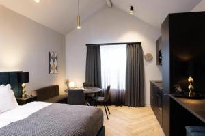 une chambre d'hôtel avec un lit, un bureau et une table dans l'établissement Backyard Apartments by Heimaleiga, à Reykjavik