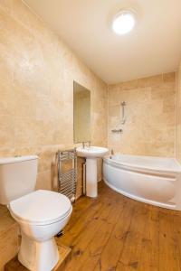 ein Badezimmer mit einem WC, einer Badewanne und einem Waschbecken in der Unterkunft The Nave - Norfolk Holiday Properties in Gorleston-on-Sea