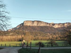 una montaña en la distancia con un campo y una carretera en Gites des Casernes, en Saint-Christophe
