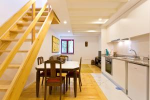 eine Küche und ein Esszimmer mit einem Holztisch und einer Treppe in der Unterkunft Douro by your side with Pool in Vila Nova de Gaia