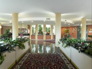 un vestíbulo con plantas en las paredes y una alfombra en Hotel Bifi, en Casalmaggiore