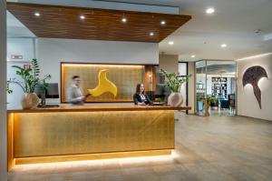 two people sitting at a counter in a lobby at Klosterhof – Alpine Hideaway & Spa in Bad Reichenhall