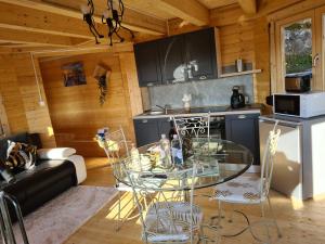 a living room with a glass table in a cabin at Gite chalet Au Paradis d Eole 