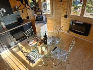 にあるGite chalet Au Paradis d Eoleのガラス張りのテーブルと椅子付きのキッチン