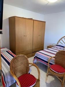 a bedroom with two chairs and a bed and cabinets at DONNA CONCETTA HOUSE in Ravello