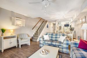 a living room with two couches and a staircase at Oceanblock 61st C102 in Ocean City