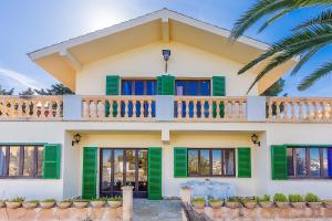 a house with green shutters and a balcony at Can Sard in Portocolom