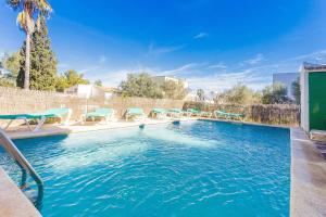 una piscina con sillas azules en un patio en Can Sard, en Portocolom