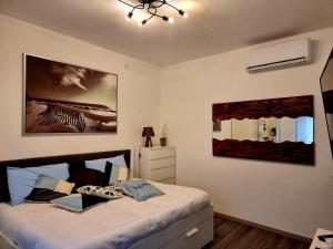 APPARTAMENTO STELLA MARE في لينانو سابيادورو: غرفة نوم بسرير وصورتين على الحائط