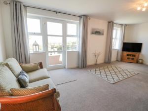 a living room with a couch and a television at Benllech Coastal Retreat in Benllech