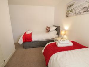 um quarto com 2 camas e uma mesa com um candeeiro em Benllech Coastal Retreat em Benllech