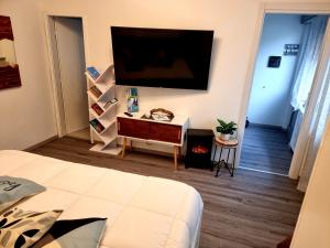 a bedroom with a large tv on the wall at APPARTAMENTO STELLA MARE in Lignano Sabbiadoro