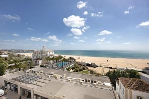 a view of a beach with a building and the ocean at Frente Mar in Portimão