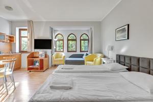 a bedroom with a large bed and a kitchen at Apartamenty Zacisze & by Noclegi Renters in Sopot