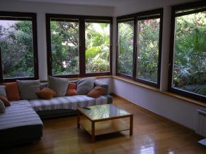 a living room with a couch and many windows at Apartments Premantura in Premantura