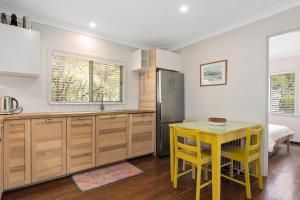 a kitchen with a yellow table and yellow chairs at Peaceful and Renovated Original Beach House with Sweeping Views of Gracetown in Gracetown