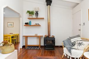a living room with a chair and a stove at Peaceful and Renovated Original Beach House with Sweeping Views of Gracetown in Gracetown