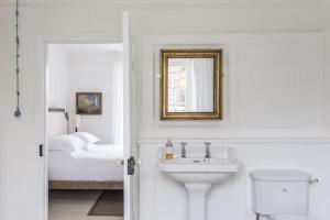 a white bathroom with a sink and a bed at Antonia's Pearls in St Austell +41 photos