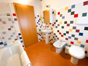 a bathroom with two toilets and a sink and a tub at Casa Vacanze di Arlecchino in San Giovanni Bianco