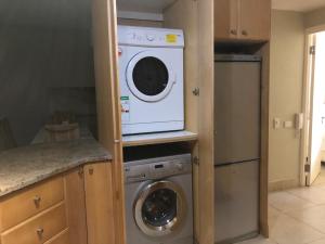 a kitchen with a washing machine and a microwave at Mystique No 9 in Shelly Beach