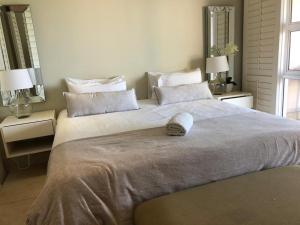 1 cama grande en un dormitorio con 2 mesitas de noche en Mystique No 9, en Shelly Beach